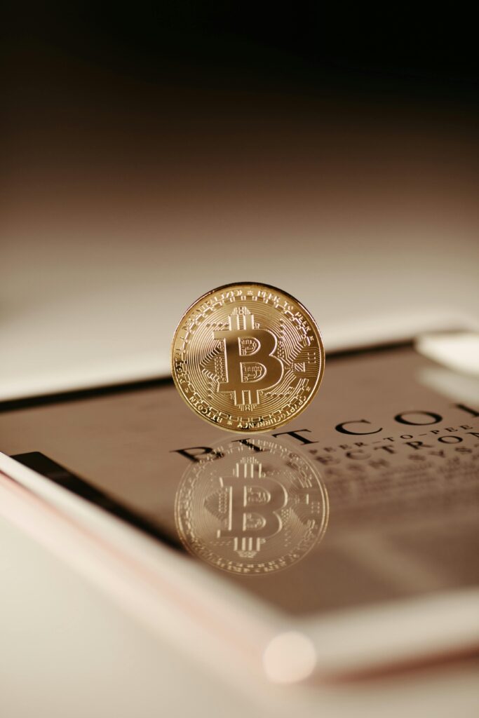 Close-up view of a Bitcoin coin reflecting on a tablet, symbolizing cryptocurrency technology.